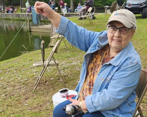Resident fishing by a serene pond during an outdoor activity