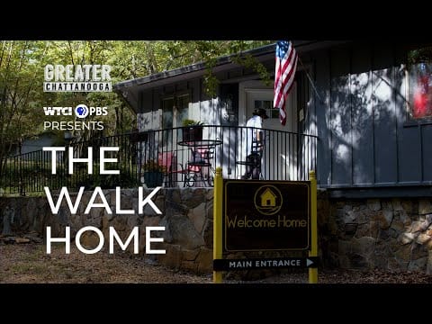 Resident standing on the porch with an American flag