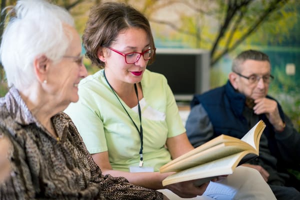 Staff reading to residents in a cozy setting