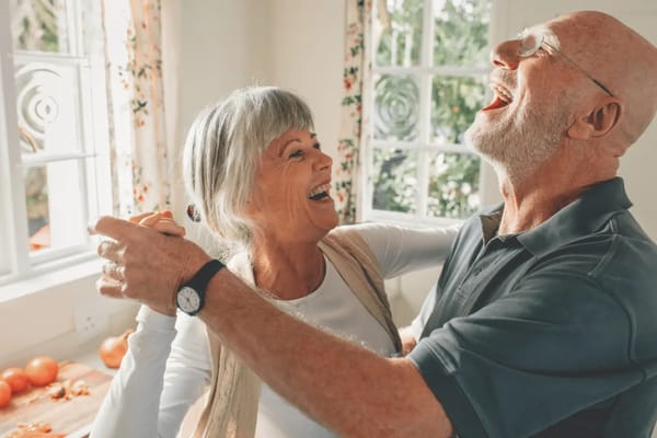 Happy senior couple dancing in a bright indoor space