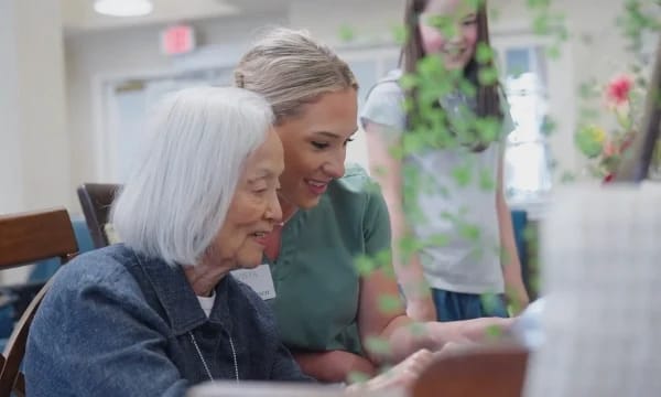 A caregiver interacting with a resident at a table