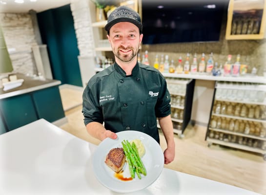 Chef presenting a gourmet meal in the dining area