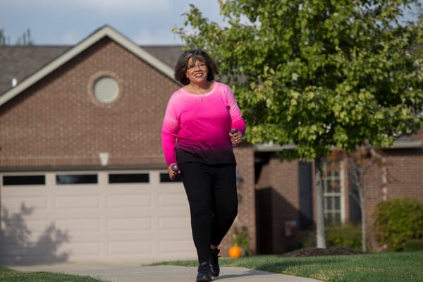 Resident enjoying a walk outside in front of a home