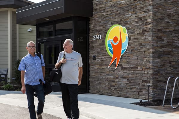 Two residents walking outside the facility entrance