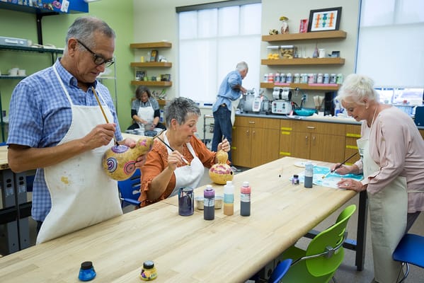 Residents engaging in a painting activity in a colorful room