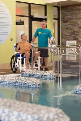 A therapist assisting a resident by the pool