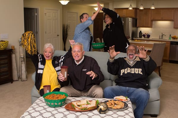 Residents enjoying a game day gathering in an activity room
