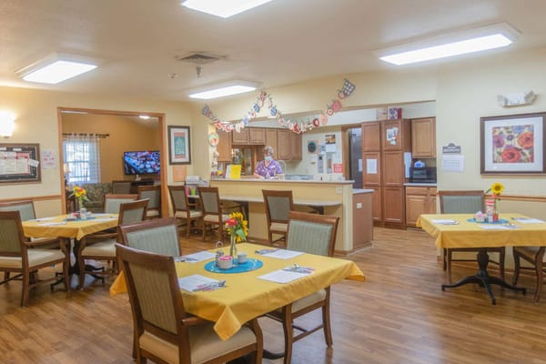 Bright dining room with tables and staff member