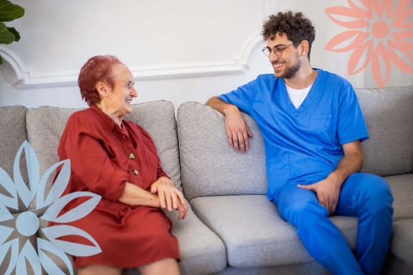 Staff member conversing with a smiling resident in a common area