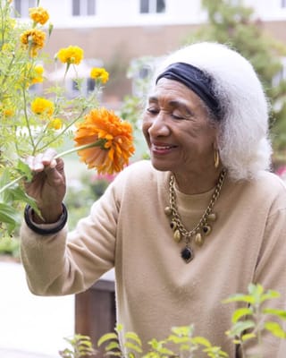 Resident enjoying flowers in a garden setting