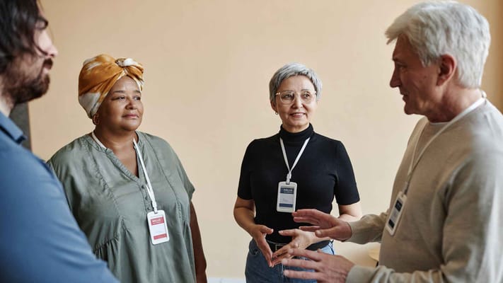 Residents and staff engaged in conversation indoors