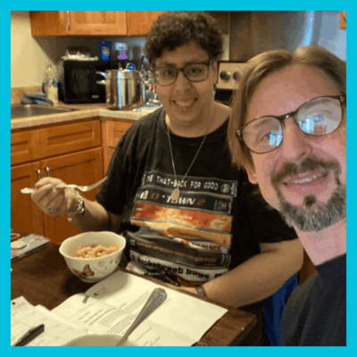 Resident enjoying a meal with staff in a cozy kitchen setting