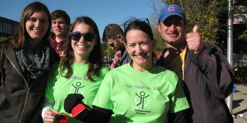 A group of smiling people in event shirts