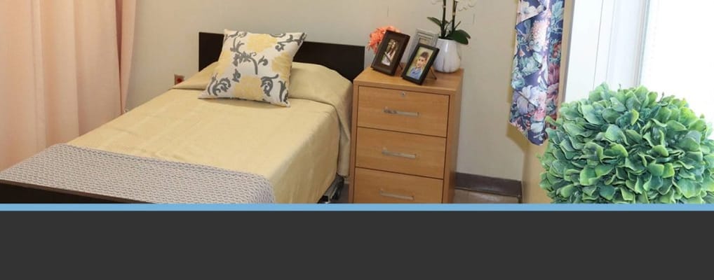 Well-furnished private resident room with a bed and dresser