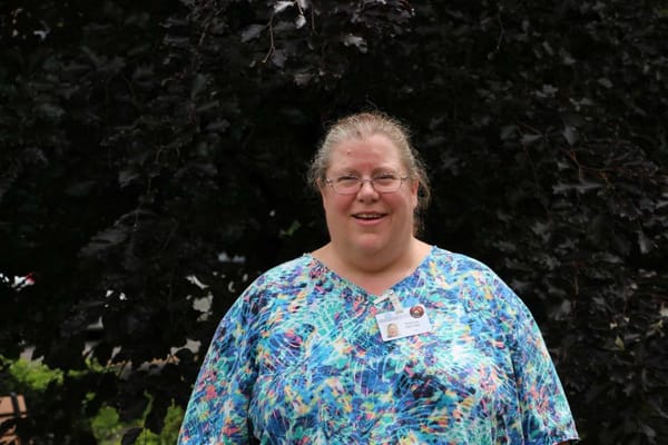 Staff member smiling in front of a tree