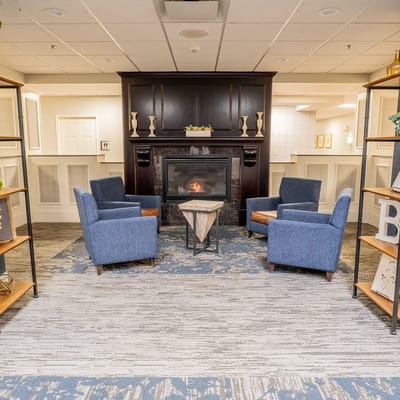 Cozy lobby area with blue chairs and a fireplace
