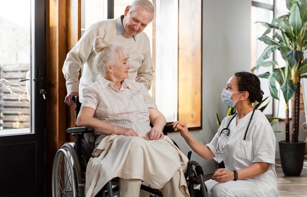 Healthcare staff assisting a resident in a bright room