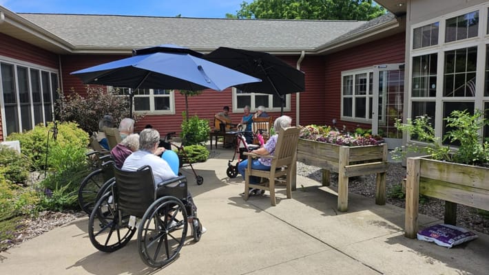 Residents enjoying time in an outdoor area with umbrellas