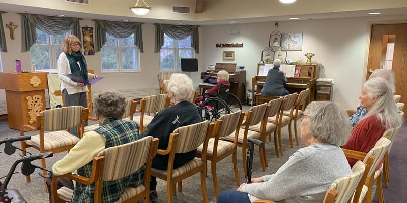 Residents participating in a piano lesson in the activity room