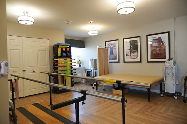A rehabilitation room with exercise equipment and therapy space