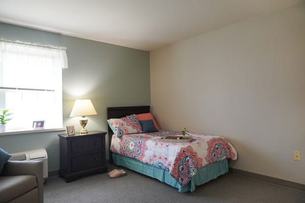 Cozy resident room with bed and lamp