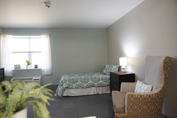 Private resident room with bed and chair