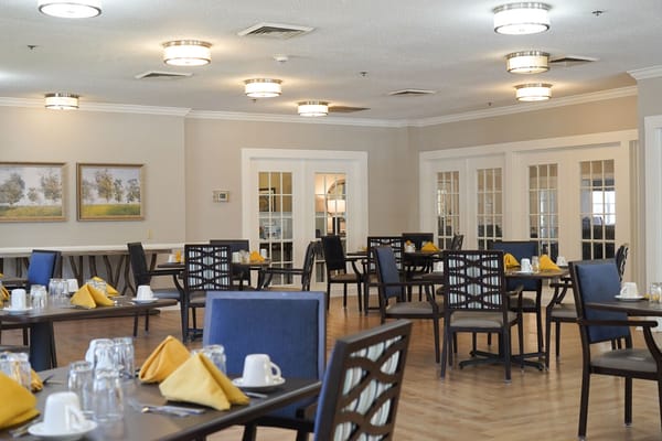 Dining area with neatly set tables and yellow napkins