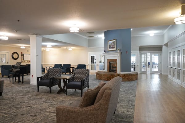 Common area with seating and fireplace in a senior living facility
