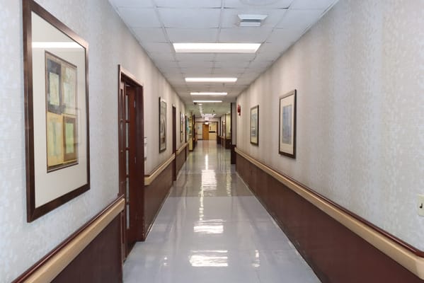 A hallway with framed artwork and smooth floor