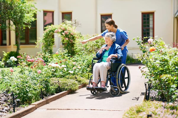 Caregiver assisting a resident in a garden