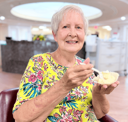 Resident enjoying dessert in a cozy common area