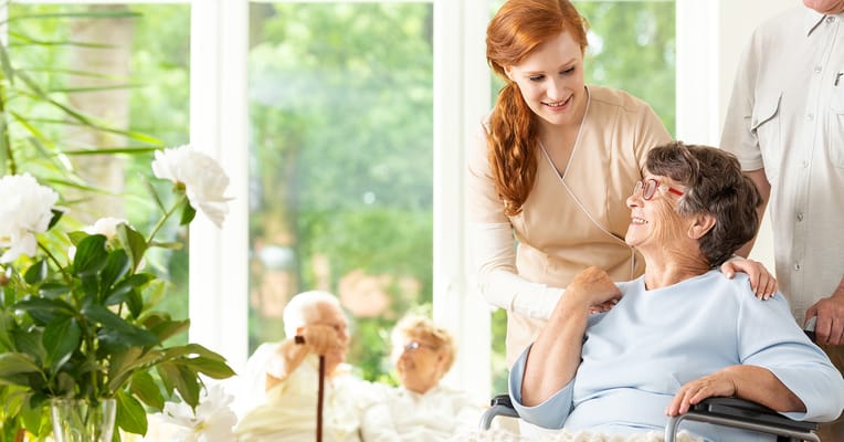 Nurse assisting a resident in a bright common area