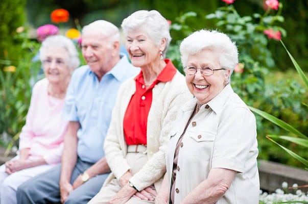 Group of smiling residents in a garden setting