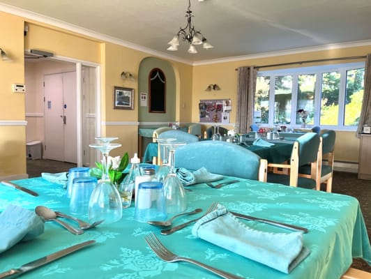 Dining room setup with blue tablecloths and glassware