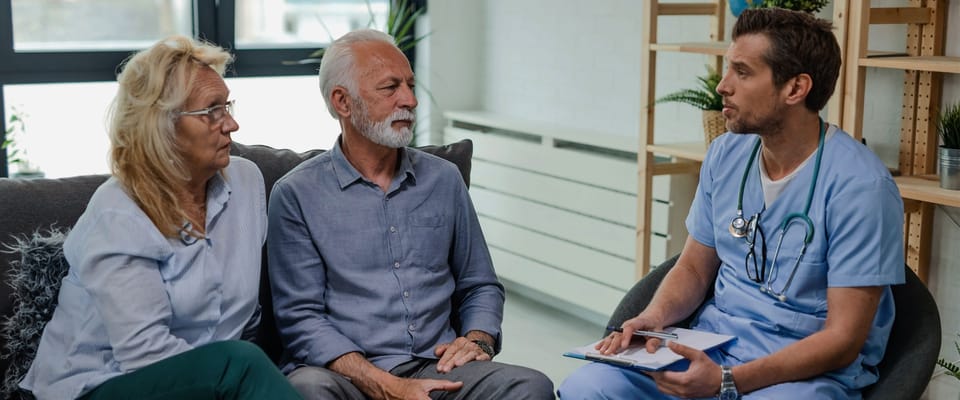 Healthcare professional consulting with a couple in an indoor setting