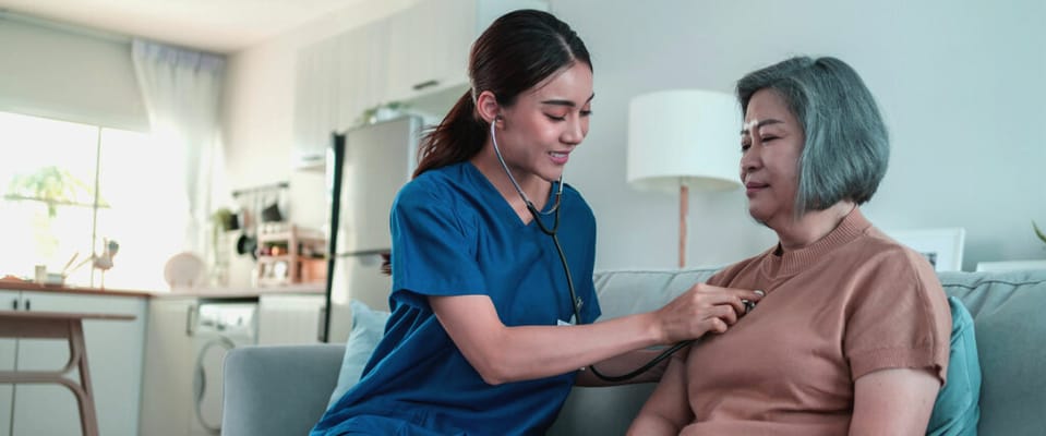 Healthcare professional attending to a resident in a cozy living room