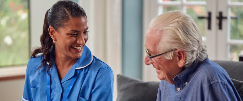 Staff member interacting with a senior resident in a common area