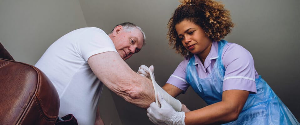 Caregiver assisting a senior with a bandage