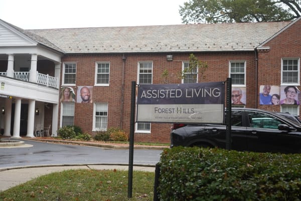 Exterior view of Forest Hills assisted living facility with sign