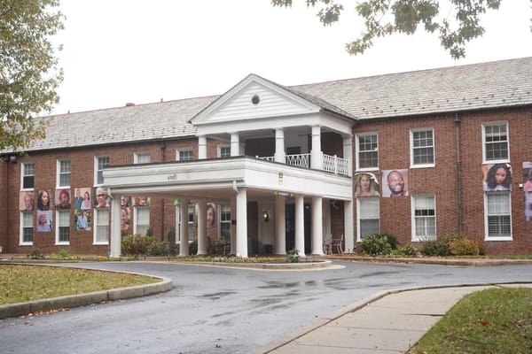 Exterior view of a senior living facility with resident portraits