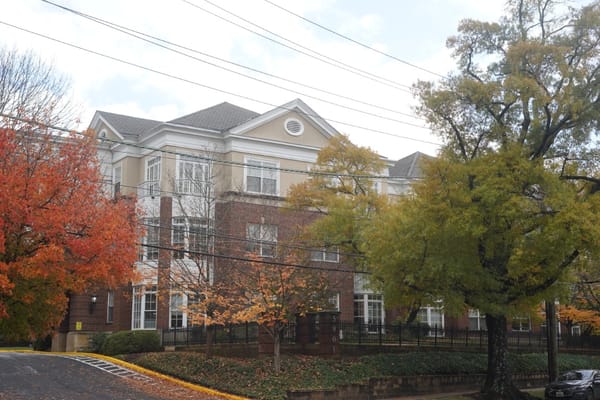 Exterior view of a senior living facility surrounded by trees