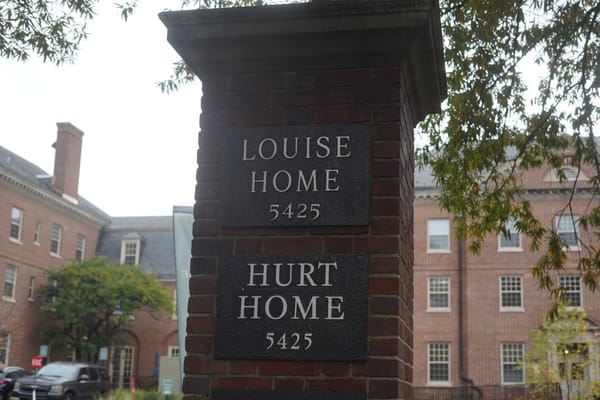 Signage displaying Louise-Hurt Home in a brick structure