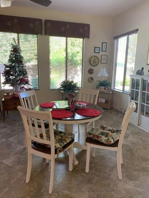Dining table with chairs in a sunny room decorated for the holidays.