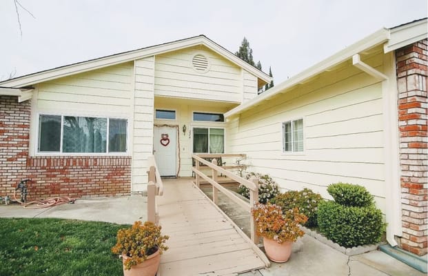 Exterior view of a senior care facility with ramp and flowers