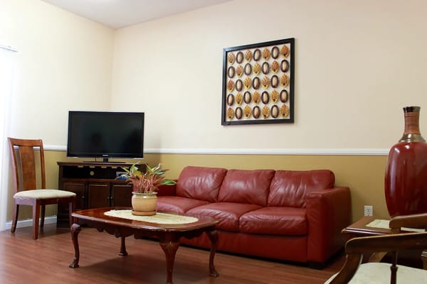 Cozy living room with a red leather couch and a TV