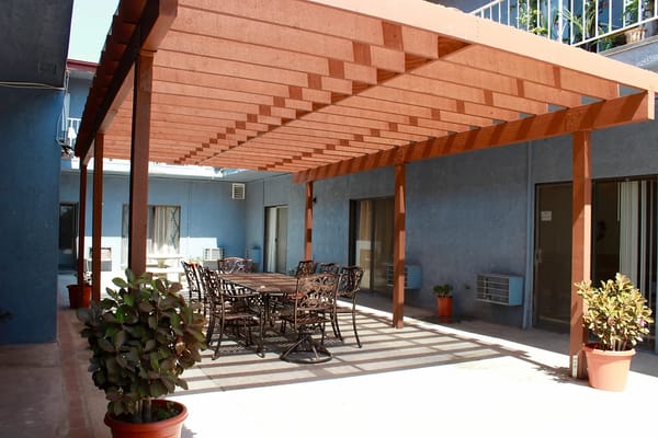 Patio area with a large table and chairs under a pergola