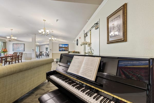 Piano in a well-lit common area with dining space