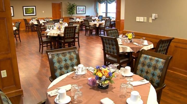 Bright dining area with neatly set tables and flowers