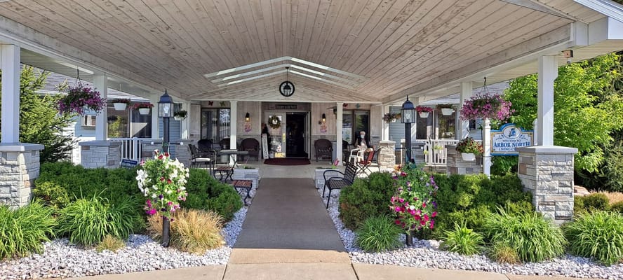 Welcoming entrance with seating and flowers at Arbor North Living Center