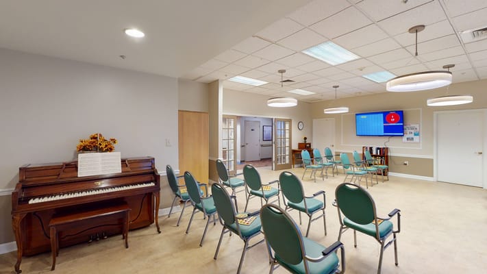 Bright common area with chairs and a piano